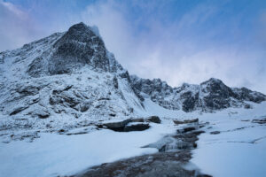 A stream flows down from mountain in Norway during Winter