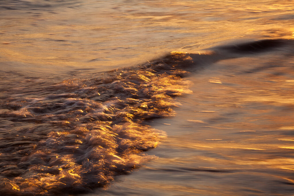 Gentle ocean waves at sunset